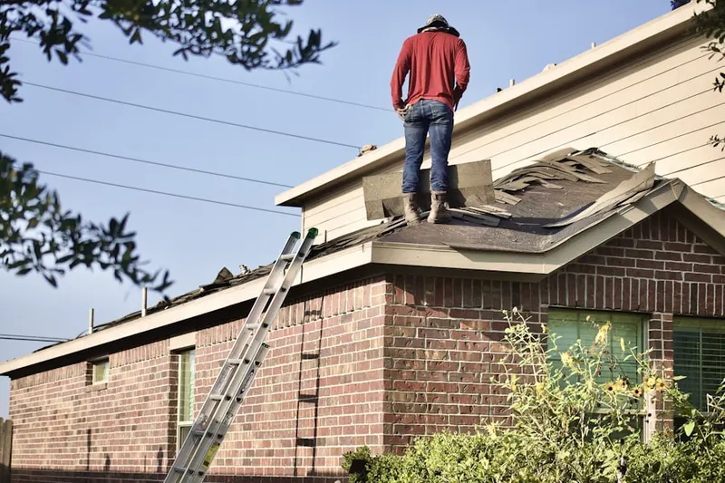 Professional roofer working on a residential roof in Corcoran